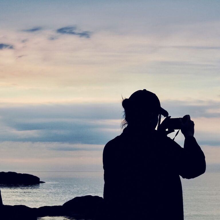 a-woman-in-silhouette-from-behind-taking-a-picture-2022-11-14-04-53-06-utc
