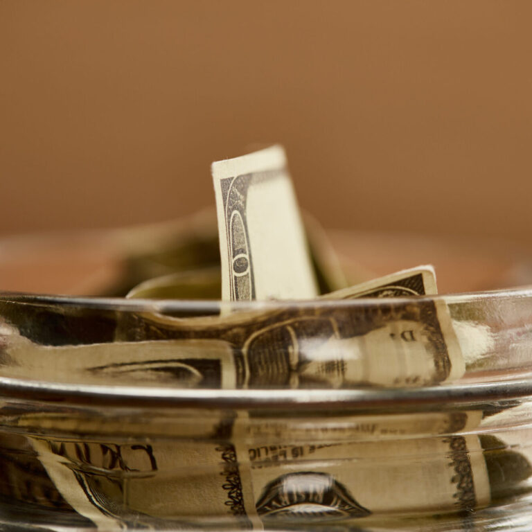close up view of glass jar with dollar banknotes