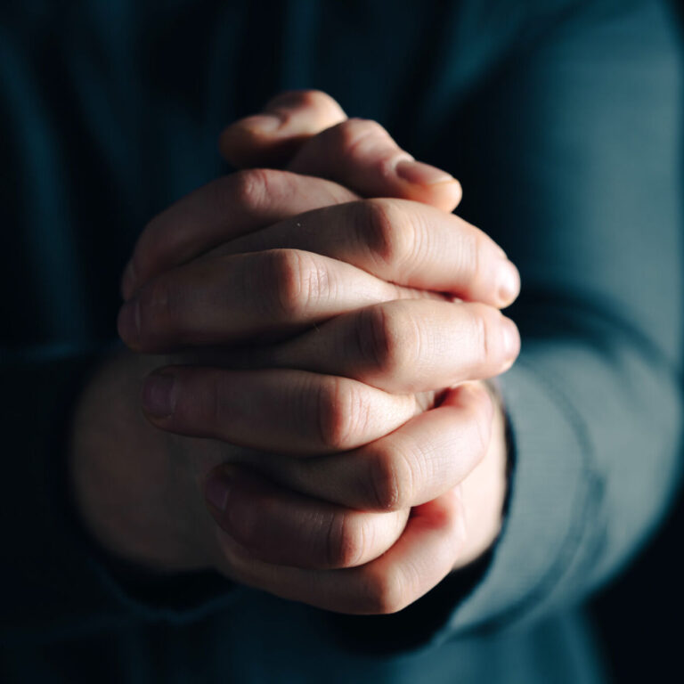 Praying hands with faith in religion and belief in God on dark background. Power of hope or love and devotion.